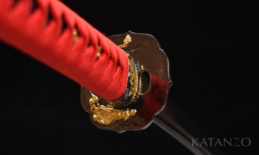 Tsuka mit schwarzem Rochenhaut-Imitat, roter Wicklung und schwarz-goldener Tsuba mit Drachenmotiven