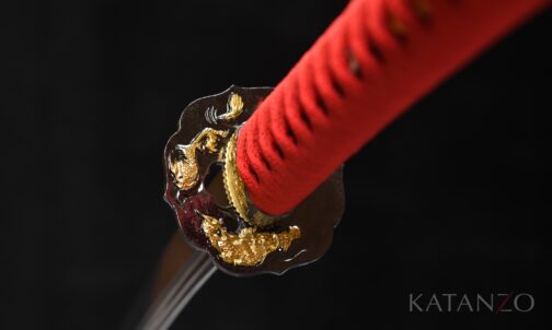 Tsuka mit schwarzem Rochenhaut-Imitat, roter Wicklung und schwarz-goldener Tsuba mit Drachenmotiven