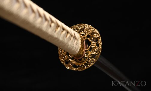 Griff des Hinoko Katana mit goldfarbener japanischer Seide, echter heller Rochenhaut und durchbrochener Messing-Tsuba mit Drachenmotiv