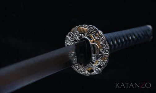 Griff des Kohakuryū Katana mit schwarzer Seidenwicklung, echter Rochenhaut und Messing-Tsuba mit Drachenmotiv